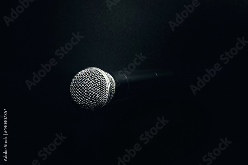 image of a microphone on a black texture background. sound concept. sound recording