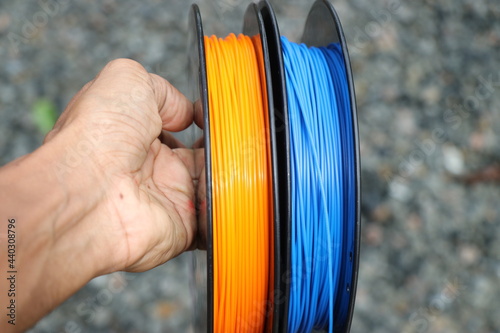 Filament for 3d printer held in hand. Material use to make this is polylactic acid or polylactide in short called as PLA Filament. photo
