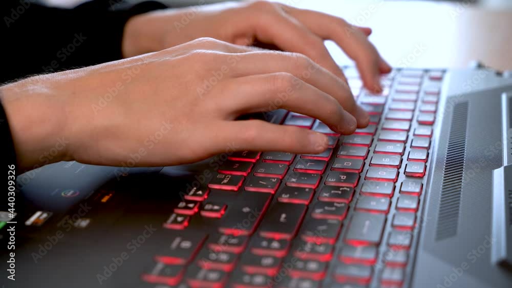 Women's beautiful hands typing on a laptop keyboard close-up. Blurred background. Women's beautiful hands typing on a laptop keyboard close-up. Blurred background.