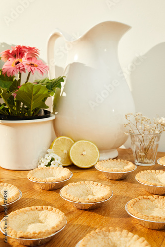 still life of empty pie crust with flowers and lemon