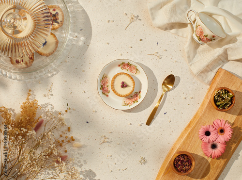 still life of small cream pies with gold spoon and tea cup
