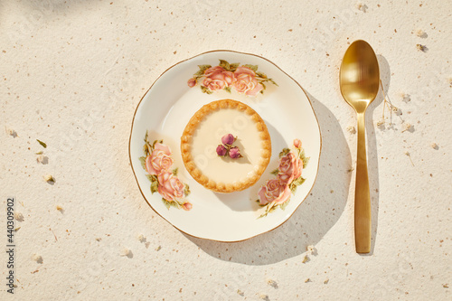 small pie with dried roses and gold spoon