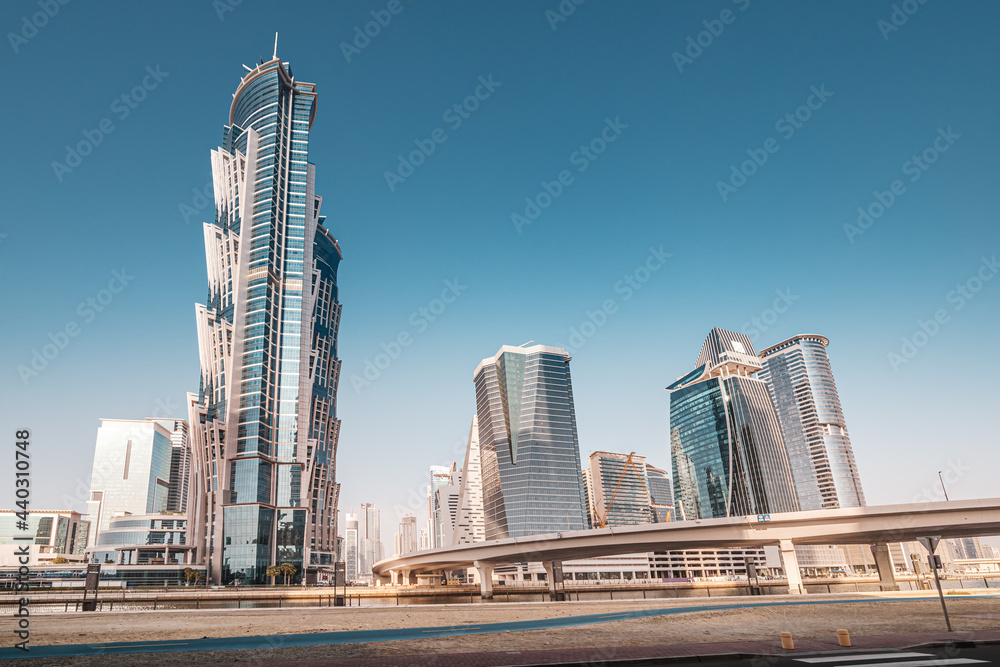 Luxury high skyscrapers with offices, hotels and residential buildings in UAE. The road over the bridge and flyover passes through the Dubai Creek Canal
