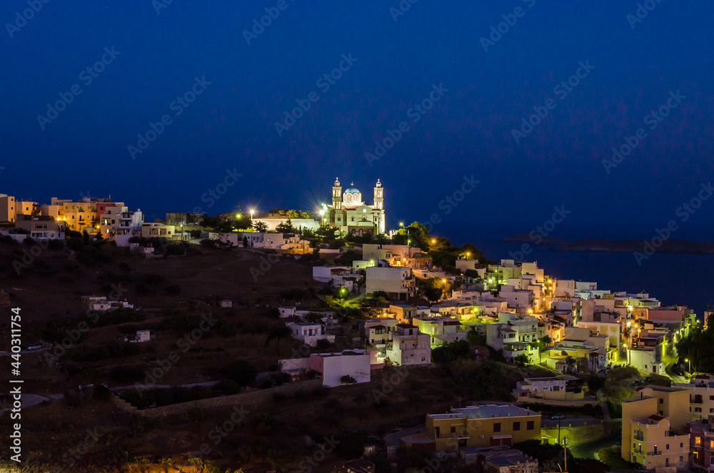 Panoramic View of Ano Syros, Greece, or Upper Side of Syros at Night. Illuminated Houses and Villas and the Christian Orthodox Church of Resurrection of Christ at the Top of the Hill