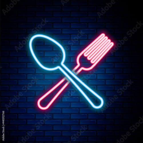 Glowing neon line Crossed fork and spoon icon isolated on brick wall background. Cooking utensil. Cutlery sign. Colorful outline concept. Vector