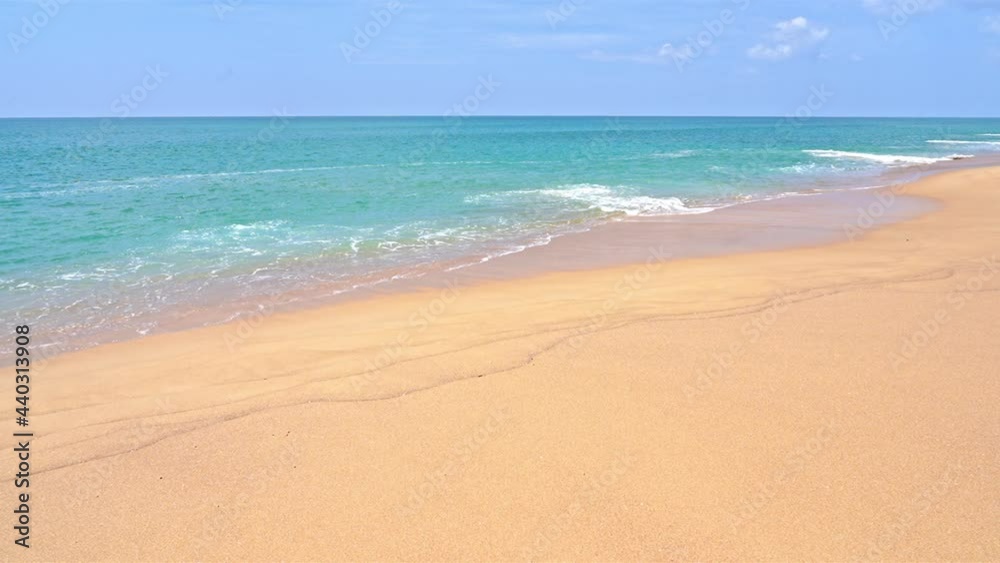 Wide golden sandy beach and calm turquoise sea of tropical island paradise. Slow motion view of little waves lapping at the shore of an exotic vacation destination. Peaceful seaside scene no people. Wide golden sandy beach and calm turquoise sea of tropical island paradise. Slow motion view of little waves lapping at the shore of an exotic vacation destination. Peaceful seaside scene no people.