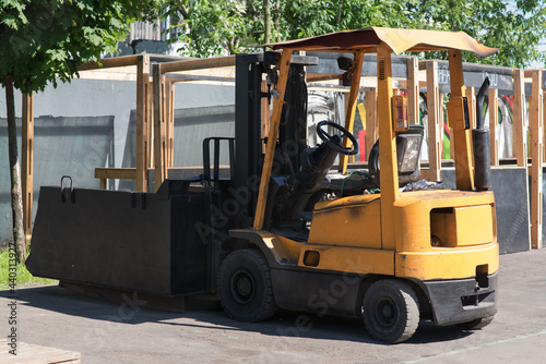 Forklift truck isolated. Hyster branded yellow forklift truck outside a factory industrial warehouse. Summer sunny day. Pneumatic equipment photo