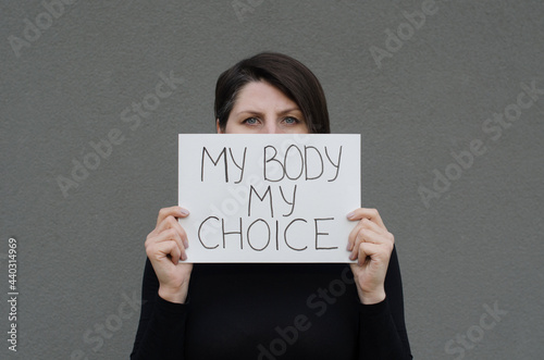 Woman showing protest banner with the message my body my choice. Right to abortion. Stop discrimination.