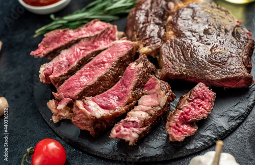 Two grilled ribeye steaks on stone background