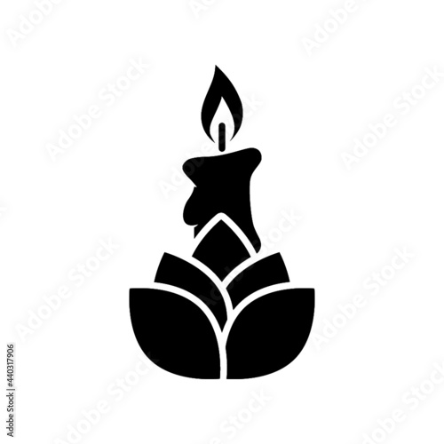 Candle and lotus flower icon isolated on white background