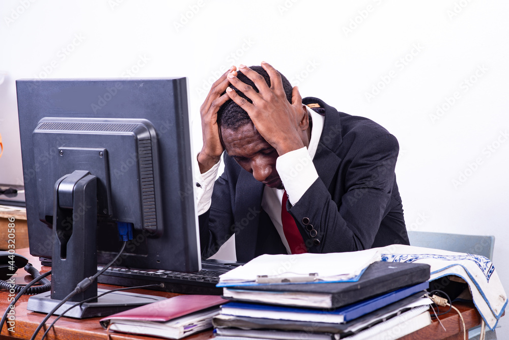 adult businessman suffering from a headache in the office. adult businessman suffering from a headache in the office.