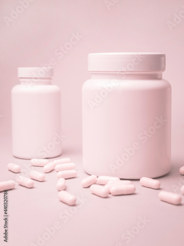 Pink pills with a pink pill bottle. 