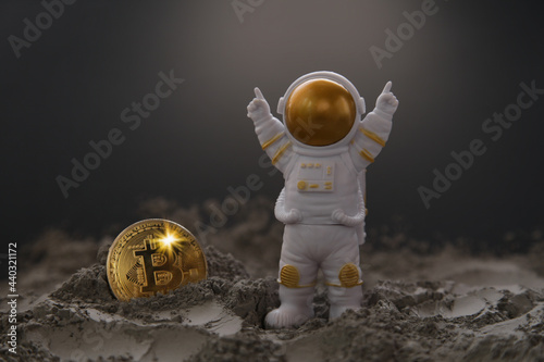 Manipulated currency valuations. Toy Astronaut, Gold Bitcoin on the Moon. Bitcoin Mining in Space concept photo