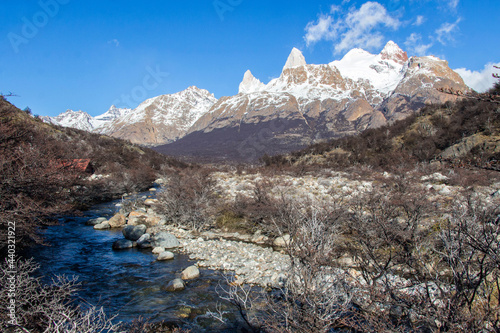 FITZ ROY, EL CHALTÉN, ARGENTINA - SEPTEMBER 12, 2017: View of Mount Fitz Roy from the start of the trek leading to the mountain. Water runs along the path on a small river. photo