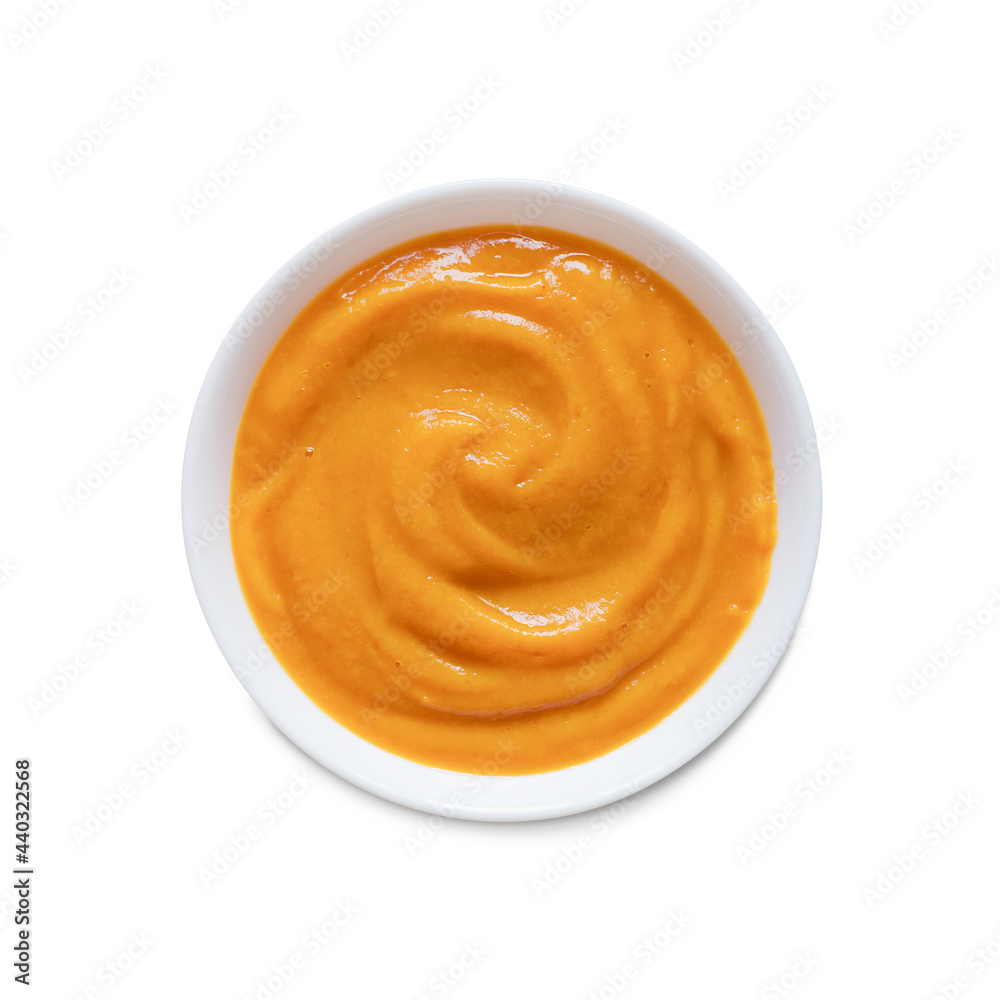Pumpkin puree in a white plate, isolated on a white background. Top view,