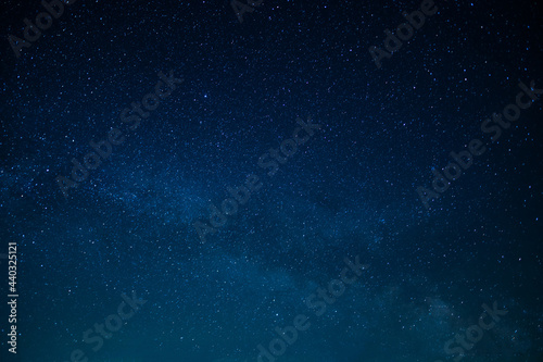 In the photo we see the Milky Way, the night sky. All shades of blue. Twinkling stars. Wallpaper. Texture. Background. High angle view. Place for your inscription. © Anton