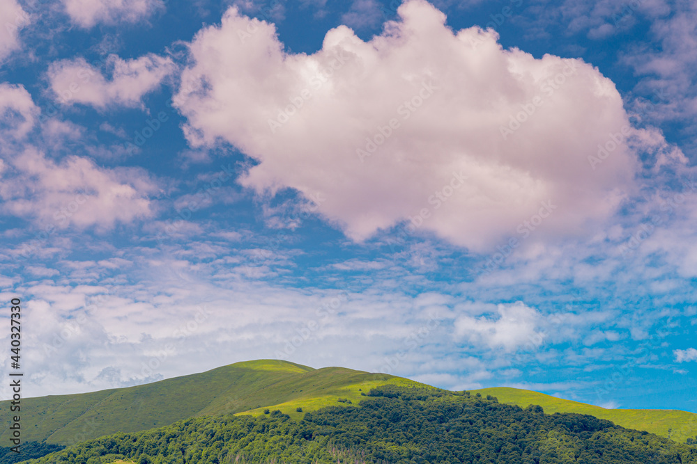 Beautiful view of green Carpathian mountain peak, under blue summer sky with clouds. Beautiful view of green Carpathian mountain peak, under blue summer sky with clouds.