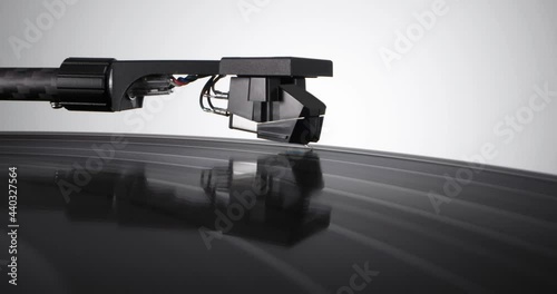 Pull-out shot of tonearm headshell descends on spinning vinyl record with colorful label. Flying above the black vintage turntable on white background
