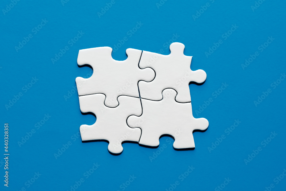 Four puzzle pieces connected to each other. Teamwork, synergy, connection, cooperation, unity or togetherness Four puzzle pieces connected to each other. Teamwork, synergy, connection, cooperation, unity or togetherness