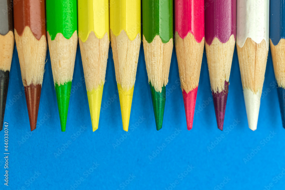 Close-up to sharp colour pencils, macro photography, blue background photo Close-up to sharp colour pencils, macro photography, blue background photo