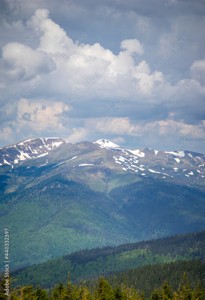 Beautiful panorama of the mountains in the summer in the snow and haze