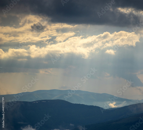 The sun's rays shine through the clouds over the Carpathian mountains