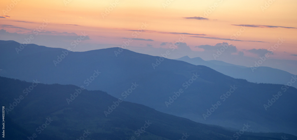 Colorful silhouettes of mountains at sunset in summer