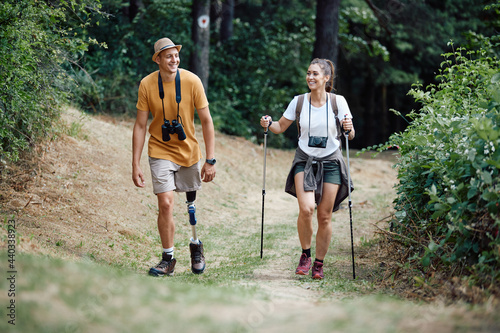 Tableau sur toile Young happy woman and her boyfriend with prosthetic leg hiking through nature