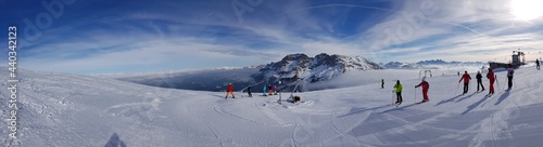 Beautiful View of Snowy Mountains And Skiers in Ski Center Latemar, South Tyrol, Italy. Dolomite Alps. Ski Resort. Ski Slopes. Slope-​bound Fun. Safety in Mountains. Holiday Destination.Ski Business.