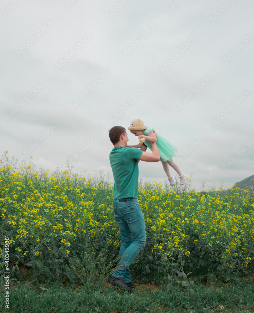 Walking daughter and father in a rapeseed field Walking daughter and father in a rapeseed field