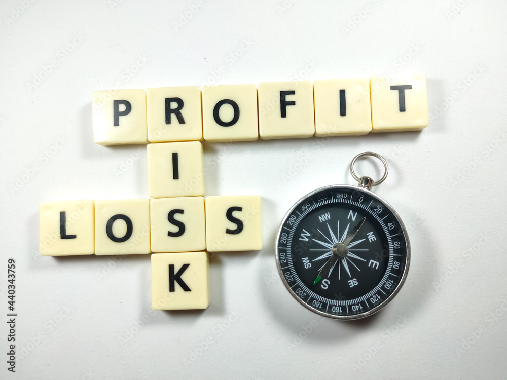 Selective focus.Scrabble letters with text PROFIT,RISK,LOSS with compass on white background. Selective focus.Scrabble letters with text PROFIT,RISK,LOSS with compass on white background.