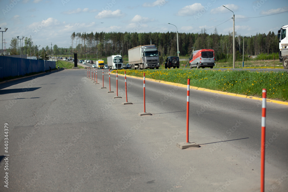 Red parking stops. Fencing the carriageway from cars. - obrazy, fototapety, plakaty 
