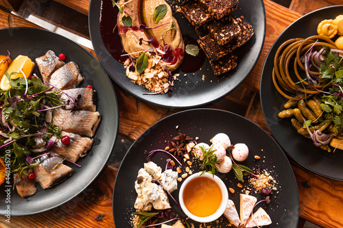 A table served in a restaurant, many different dishes and drinks on one table for a large company.