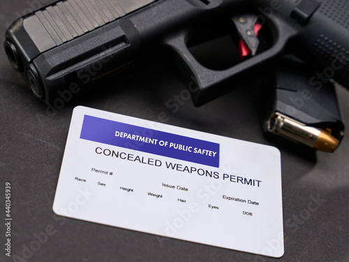 Concealed Carry Permit next to a semi-automatic handgun