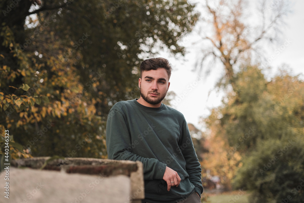 Portrait of a young handsome Caucasian man in a park