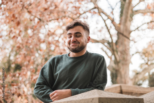 Portrait of a young handsome Caucasian man in a park