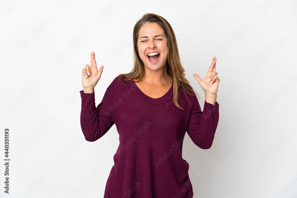 Middle age Brazilian woman isolated on white background with fingers crossing Middle age Brazilian woman isolated on white background with fingers crossing