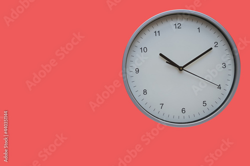 Wall clock red background. The concept of "Time is passing". Copy space.