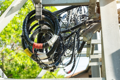 A roll of fiber-optic cables hanging from a pole. Optical fiber cable of high speed internet communication On the  green background Close focus and select an object
