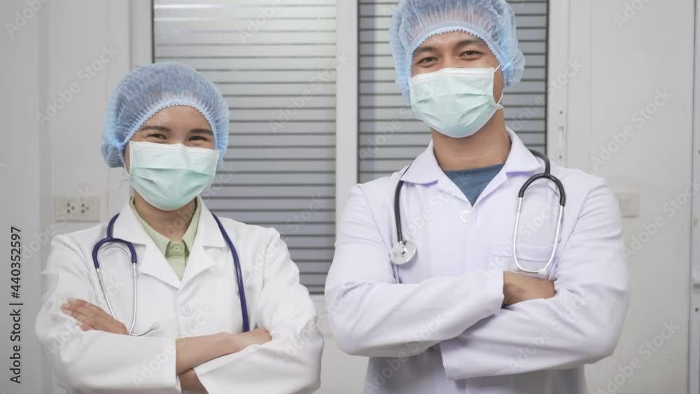 Confident professional woman doctor and nurse man smile wearing medical face mask and cap protection standing crossed arms, female portrait, Covid-19 Medicine And Health Care Concept Confident professional woman doctor and nurse man smile wearing medical face mask and cap protection standing crossed arms, female portrait, Covid-19 Medicine And Health Care Concept