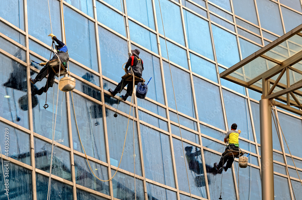window washers on the glass wall of the building