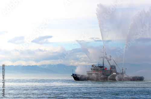 Floating tug boat is spraying jets of water