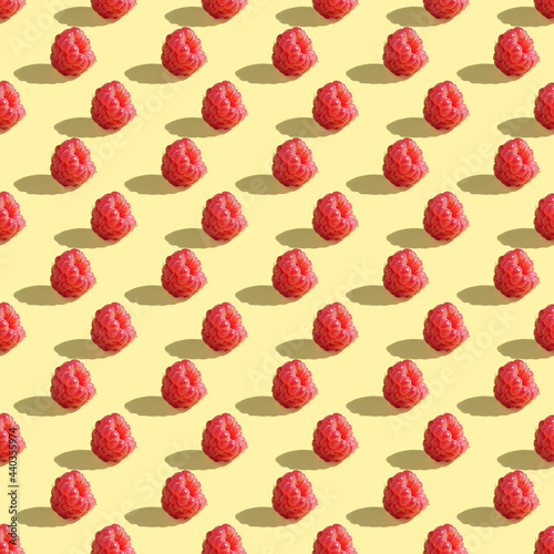Seamless pattern of raspberry berries on a yellow background.