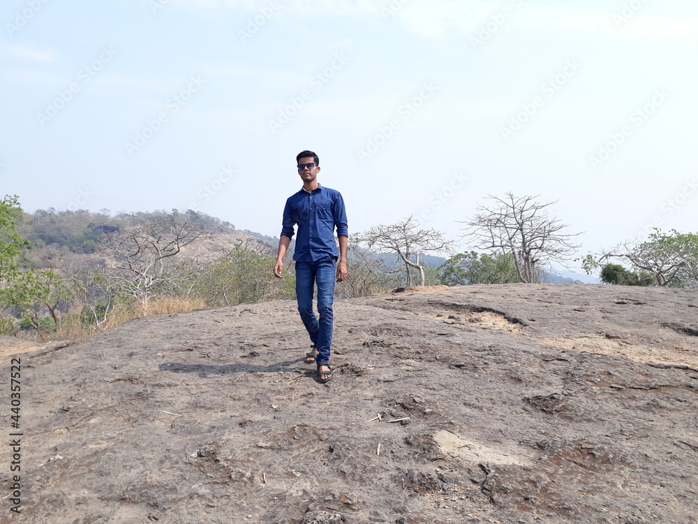 man walking on the mountain, young boy walking on over the rock, young men walking, Sanjay Gandhi National Park. man walking on the mountain, young boy walking on over the rock, young men walking, Sanjay Gandhi National Park.