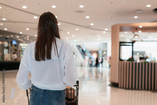back of woman walk with cart in departmentstore