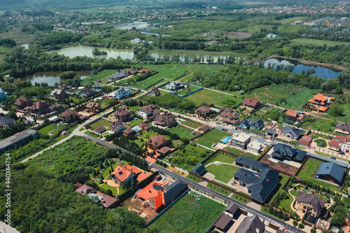 Turtle roofs of luxury houses and cottages in a natural landscape park near the city - aerial drone shot. The roofs of luxury cottages and houses are a concept of Luxury neighborhood. 