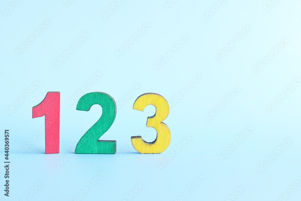 Colorful 123 numbers on wooden blocks in blue background with copy space. Start of child or kid learning counting concept. Colorful 123 numbers on wooden blocks in blue background with copy space. Start of child or kid learning counting concept.