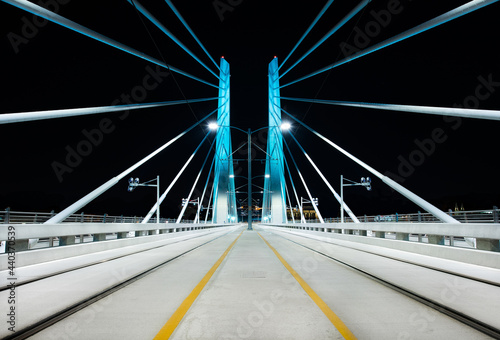 Symmetrical bridge photo from the center of the Tilikum Crossing Bridge in Portland, Oregon which spans the Willamette River.
