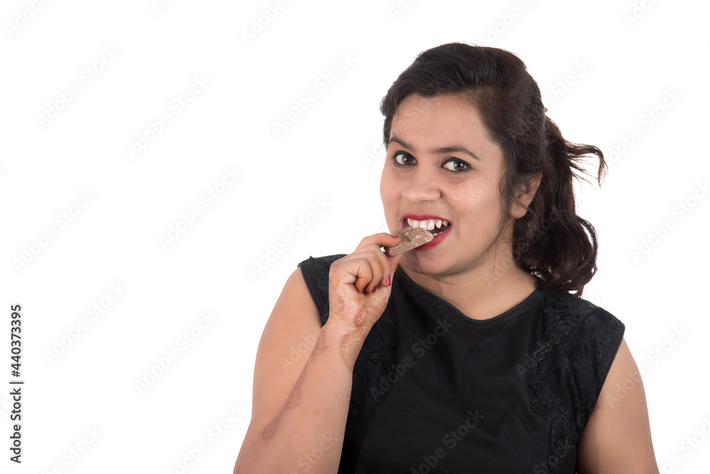 Portrait of a happy young woman eating chocolate bar isolated over white background Portrait of a happy young woman eating chocolate bar isolated over white background