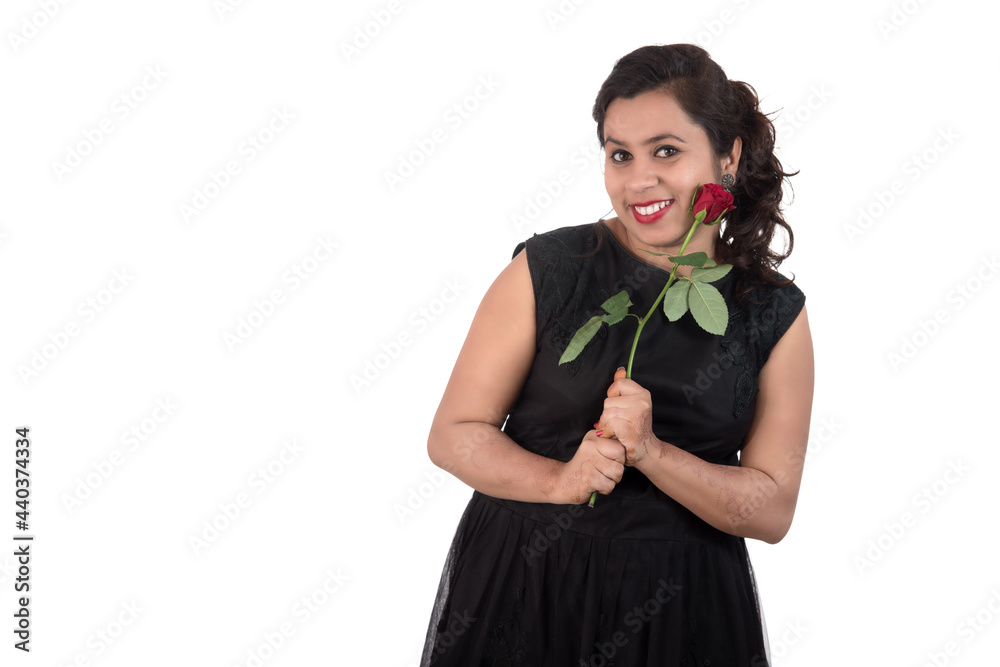 Beautiful young girl or woman holding and posing with red rose flower on white background Beautiful young girl or woman holding and posing with red rose flower on white background